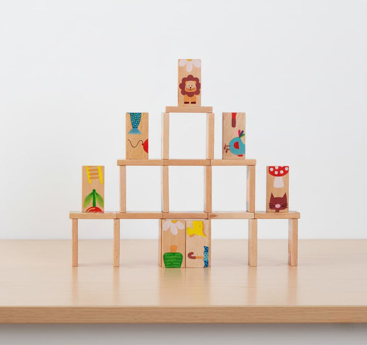 Stack of wooden blocks with animal illustrations on a light surface and white background