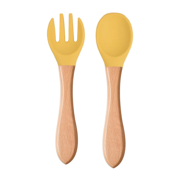 A set of green silicone spoon and fork with wooden handles designed for babies and toddlers.