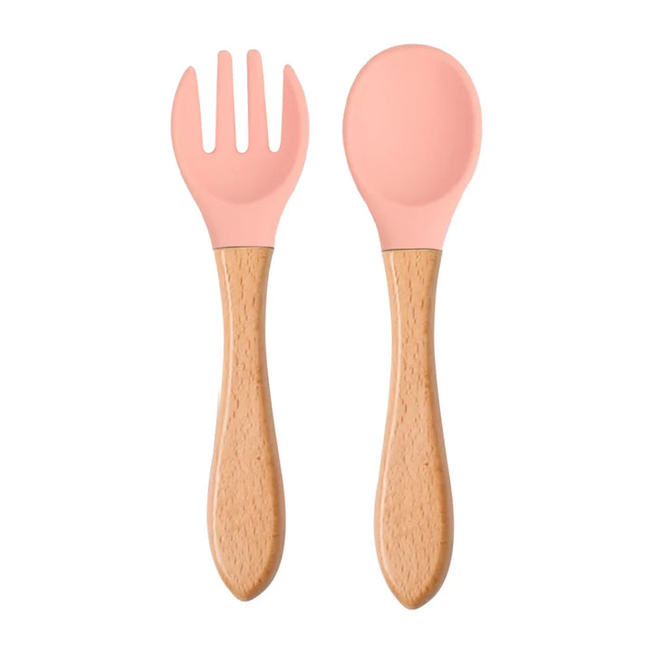 A set of green silicone spoon and fork with wooden handles designed for babies and toddlers.