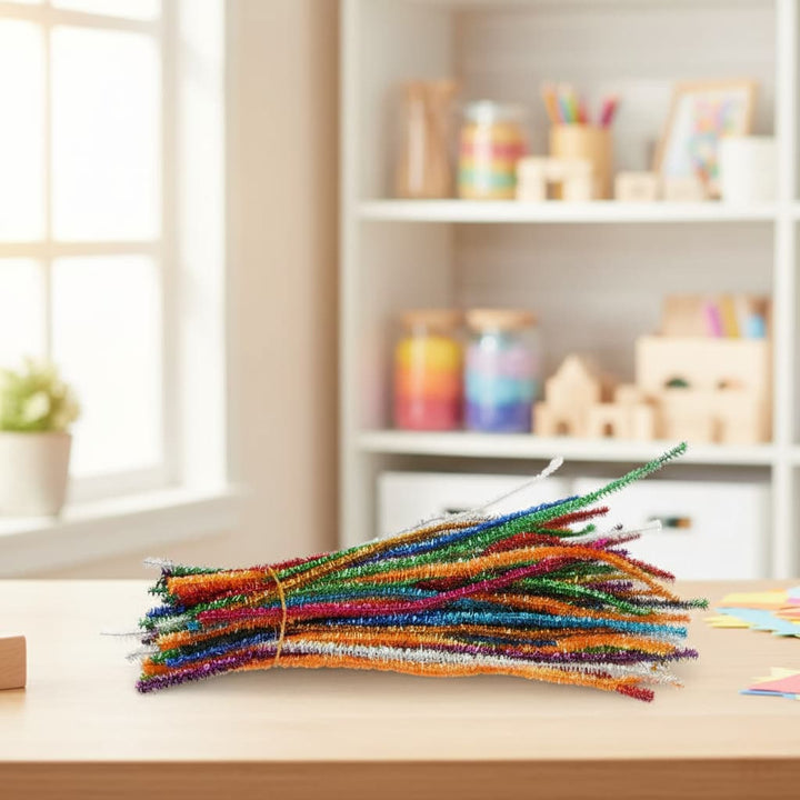 Colorful pipe cleaners on a table with a blurred background of a room with shelves and toys.