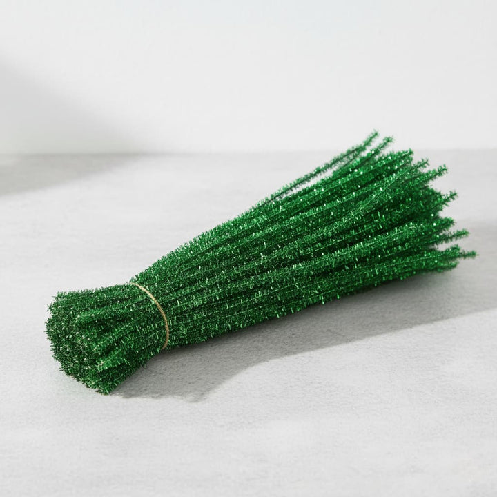 Bunch of green pipe cleaners on a light gray background